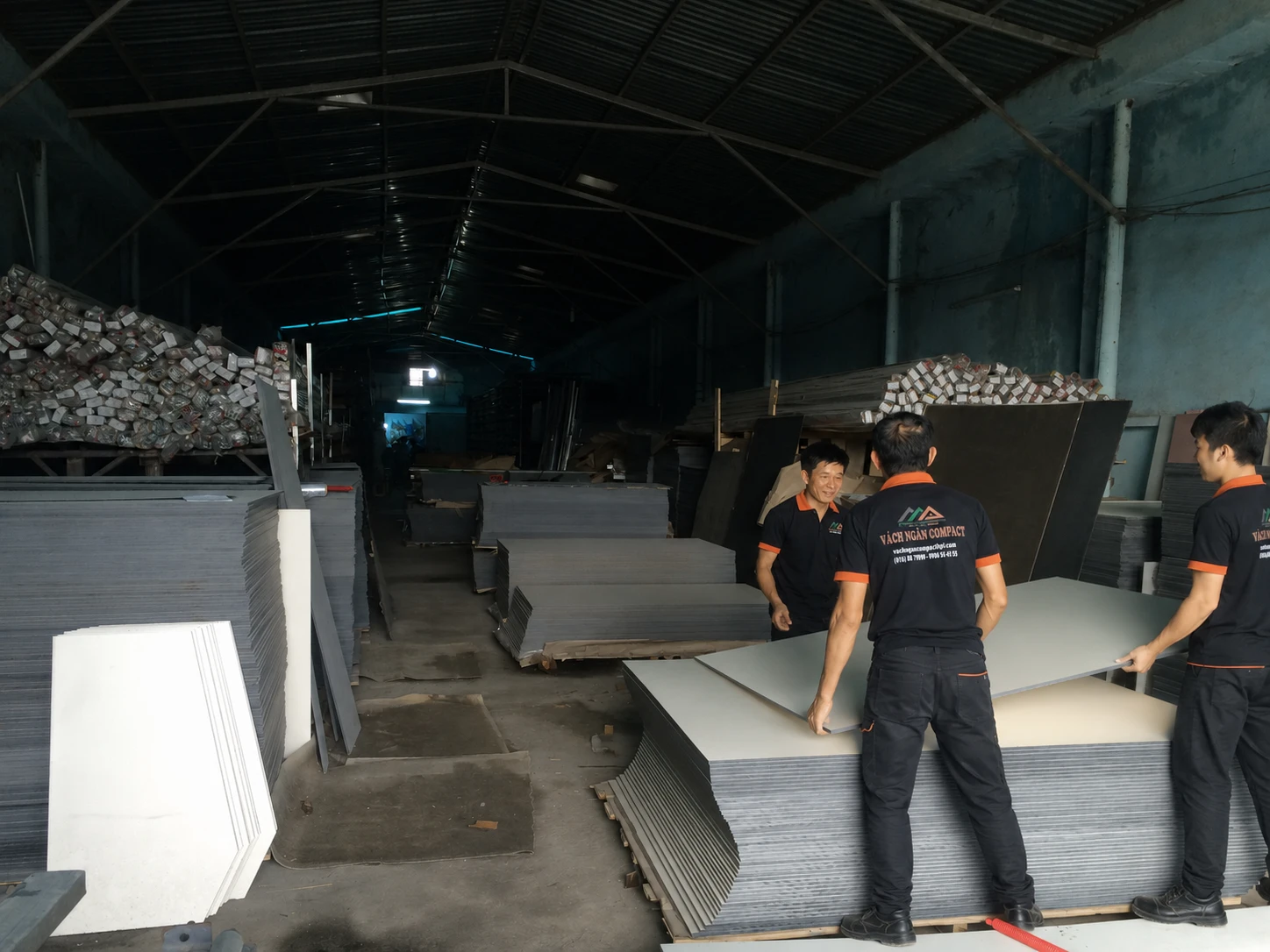 Công nhân gia công tấm Compact 12 mm màu ghi làm vách ngăn vệ sinh